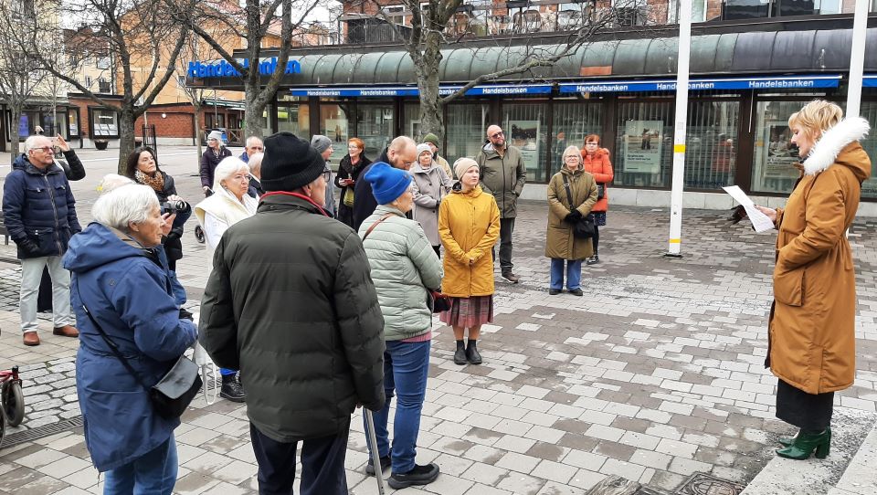 I bilden håller en kvinna ett tal framför folksamling