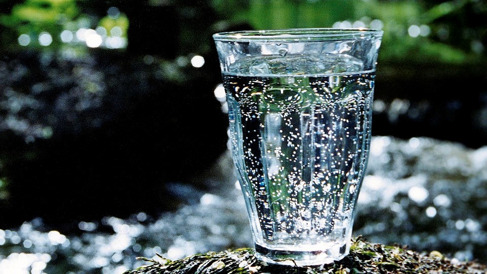 Vattenglas fyllt med vatten i naturen.