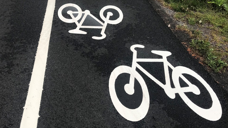 Nyasfalterad cykelväg med symboler för cykling på.