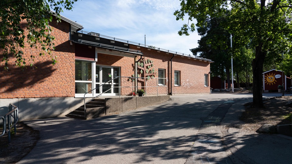 Barn i klassrum. Ler stor och bär en blå tröja.