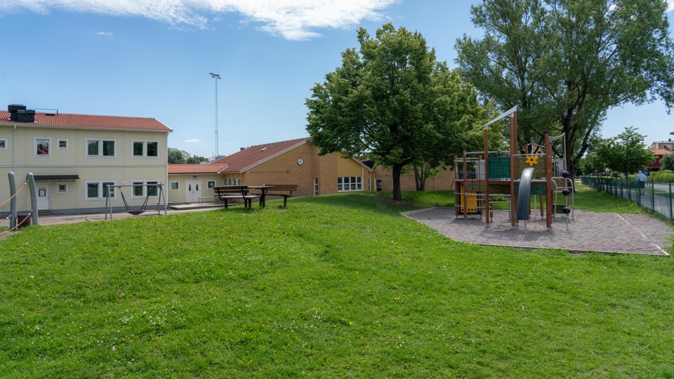 Barn i klassrum. Ler stor och bär en blå tröja.