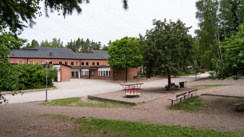 Barn i klassrum. Ler stor och bär en blå tröja.