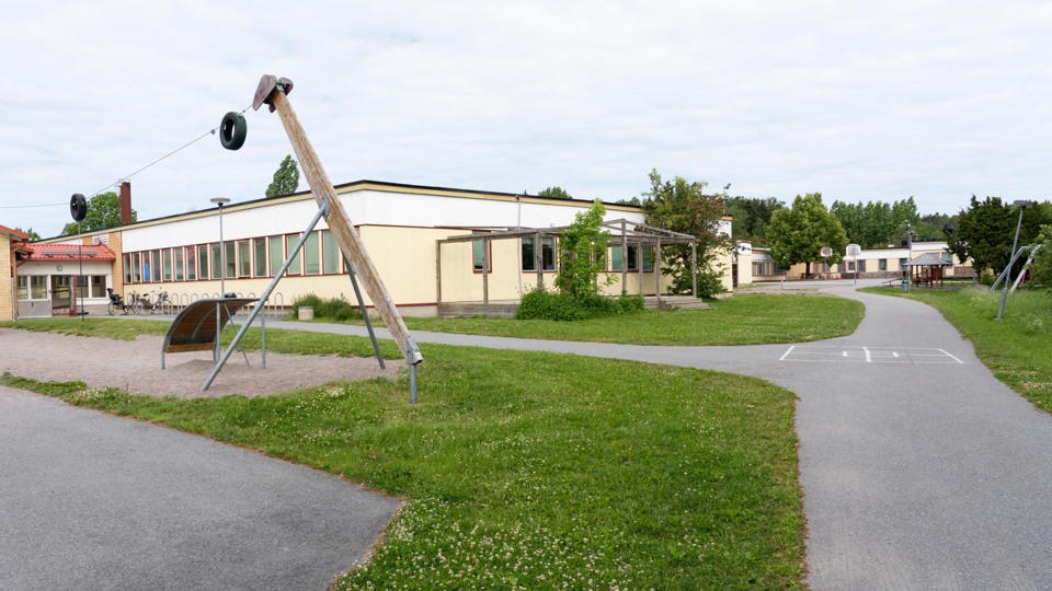 Barn i klassrum. Ler stor och bär en blå tröja.