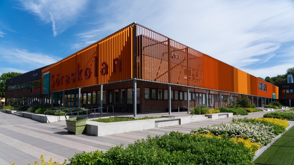 Barn i klassrum. Ler stor och bär en blå tröja.