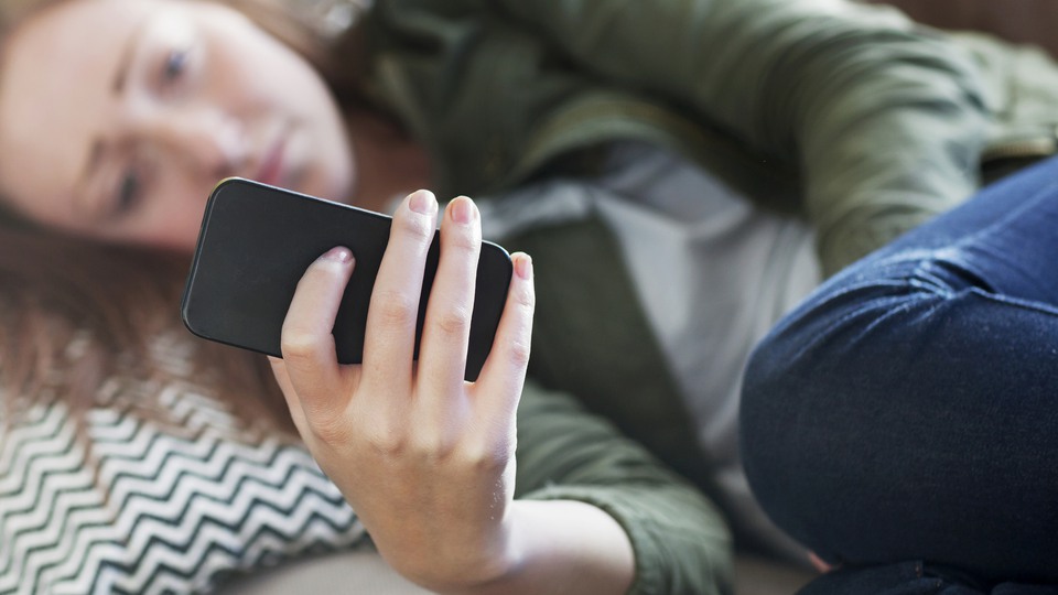 Kvinna håller i en mobiltelefon