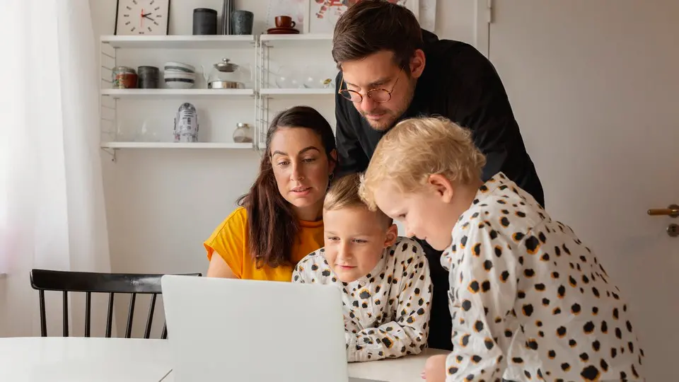 Barn sitter vi skolbänk och skriver, tittar i i kameran