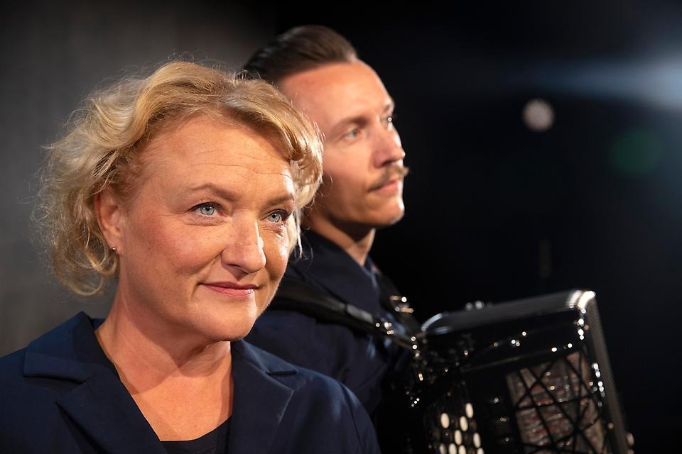 Kuvassa vaaleatukkainen nainen ja haitaria soittava mies