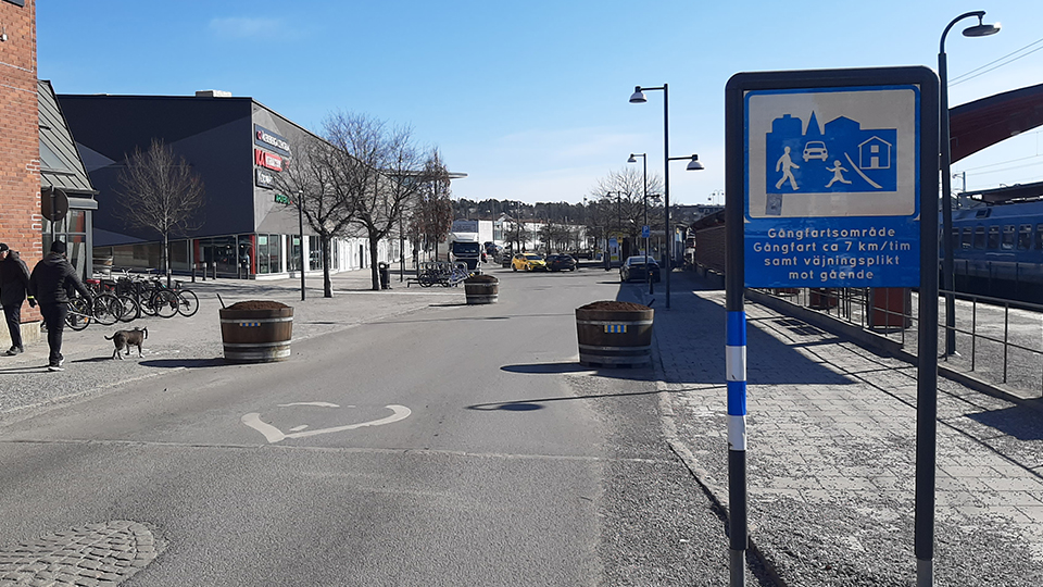 Gatumiljö som visar Stationsvägen med stora blomsterurnor som är utplacerade på vägen.