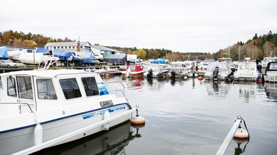 Bilden visar Dyviks marina. Några av båtarna ligger i vattnet vid bryggorna och andra är uppställda på land för vinterförvaring.