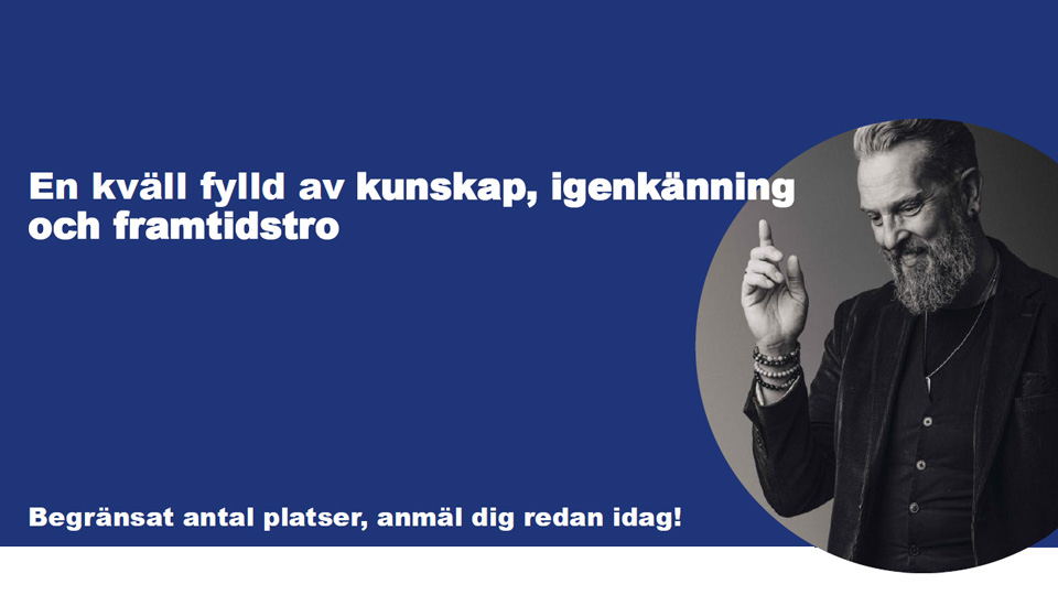 Ett foto av en man med stort skägg. Han ler och håller upp ett pekfinger.