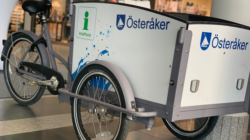 En lådcykel med Österåkers kommuns logotyp står uppställd i Åkersberga centrum.