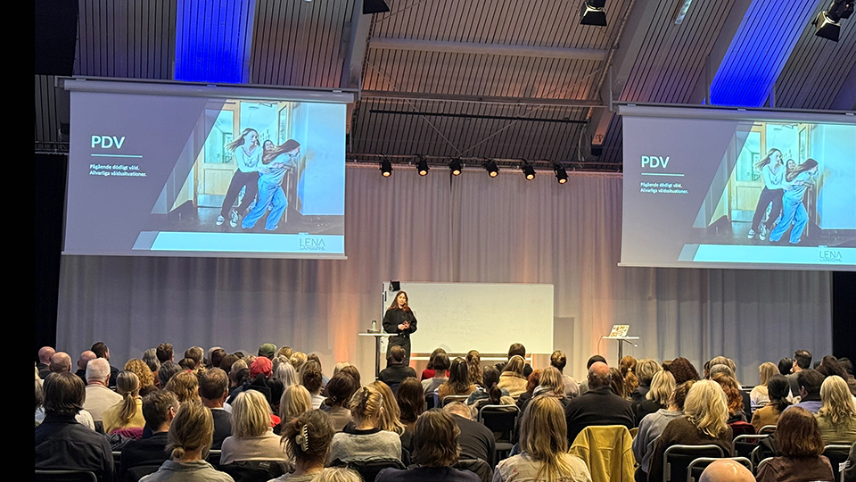 Lena Ljungdahl PDV-harjoituksessa, jatkuvaa tappavaa väkivaltaa. Hän puhuu yleisön edessä.