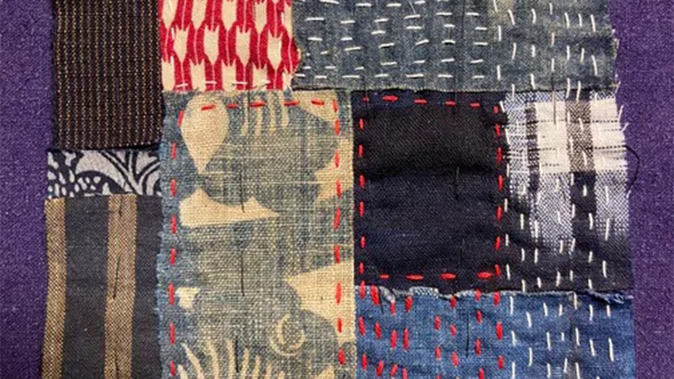 Ett collage av tygbitar som broderats och lagats.