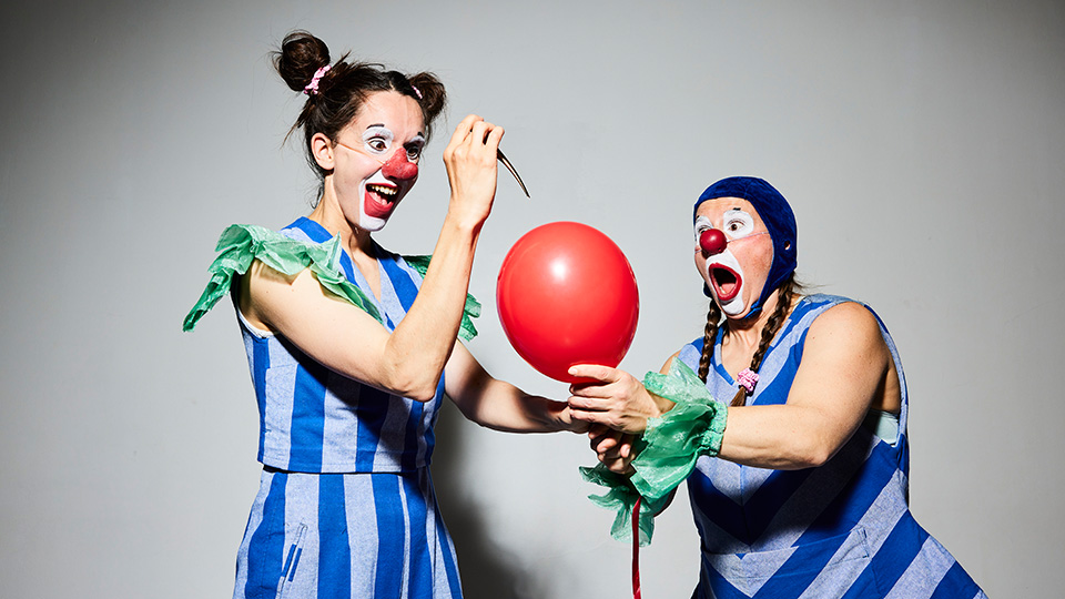 Två clowner. En vill sticka en kniv i en ballong och den andra vill rädda ballongen.