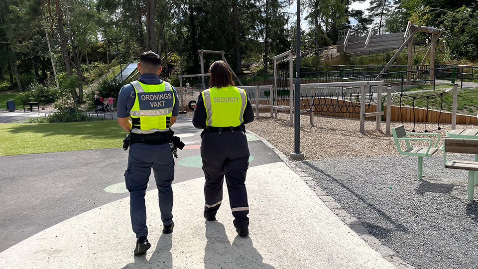 Två personer bakifrån på en lekplats