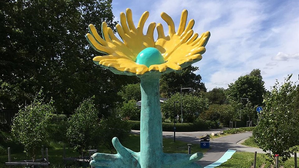 Bild på konstverket Kram - en skulptur liknande en blomma med kramande armar