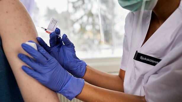 En person sticker en annan person med en vaccinspruta