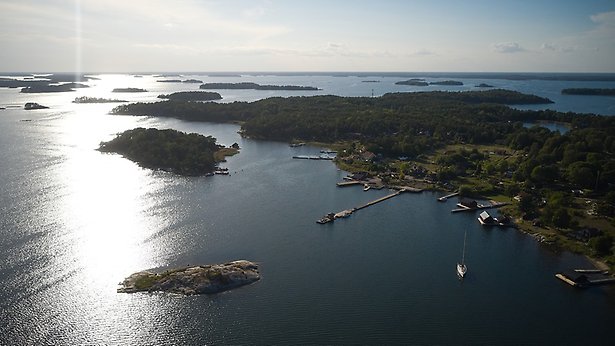 Flygfoto över skärgårdsö med båtar i förgrunden