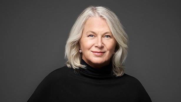 En leende kvinna med gråblond page. Hon är klädd i svart polotröja.