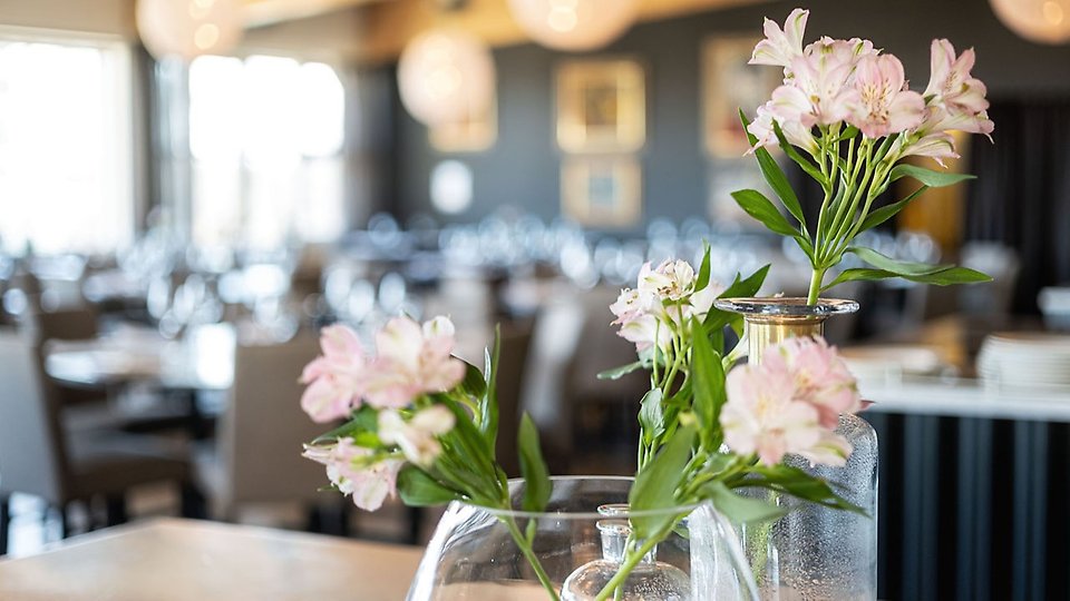 Närbild på blommor i vas i restaurangmiljö
