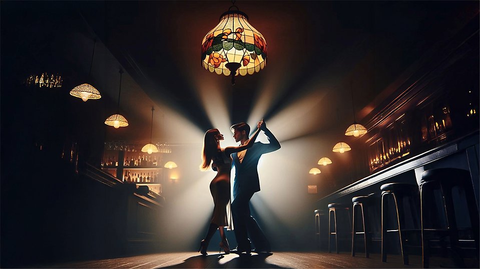 Ett par dansar under en stor Tiffanylampa i barmiljö.