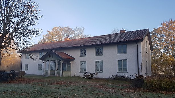 Äldre tvåvåningshus med veranda.