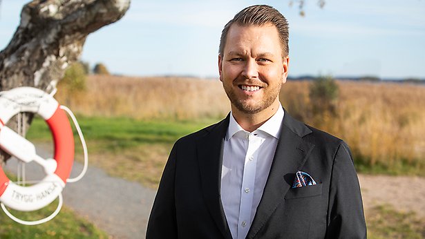 Richard Orgård står i skärgårdsmiljö med en livboj märkt Österåkers kommun bredvid.