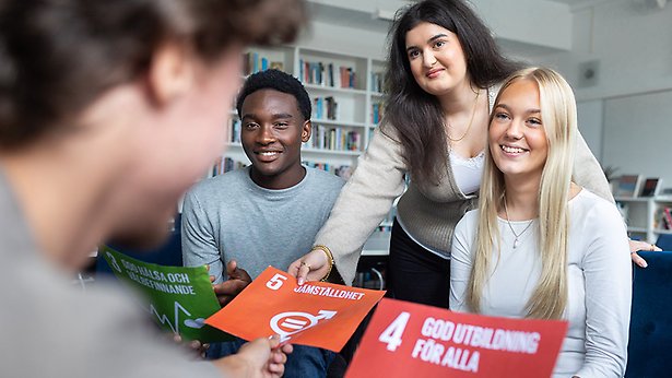 Två elever, en kille och en tjej som tittar på en dator.