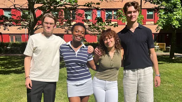 Fyra ungdomar sitter runt ett bord med mikrofoner och samtalar medan de spelar in en podd.