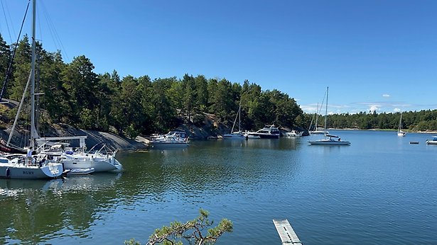 Flygfoto över skärgårdsö med båtar i förgrunden