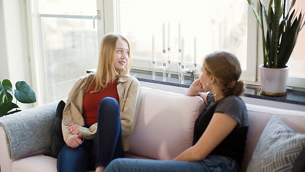 Bild på tre ungdomar som sitter på en brygga