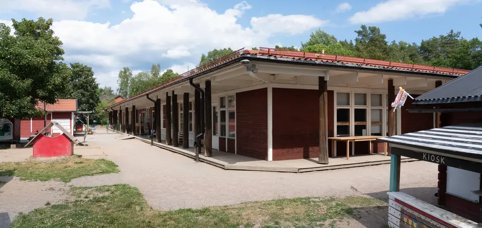 Bild på förskolan Luna, röda enplans hus som sitter ihop i grönskande miljö