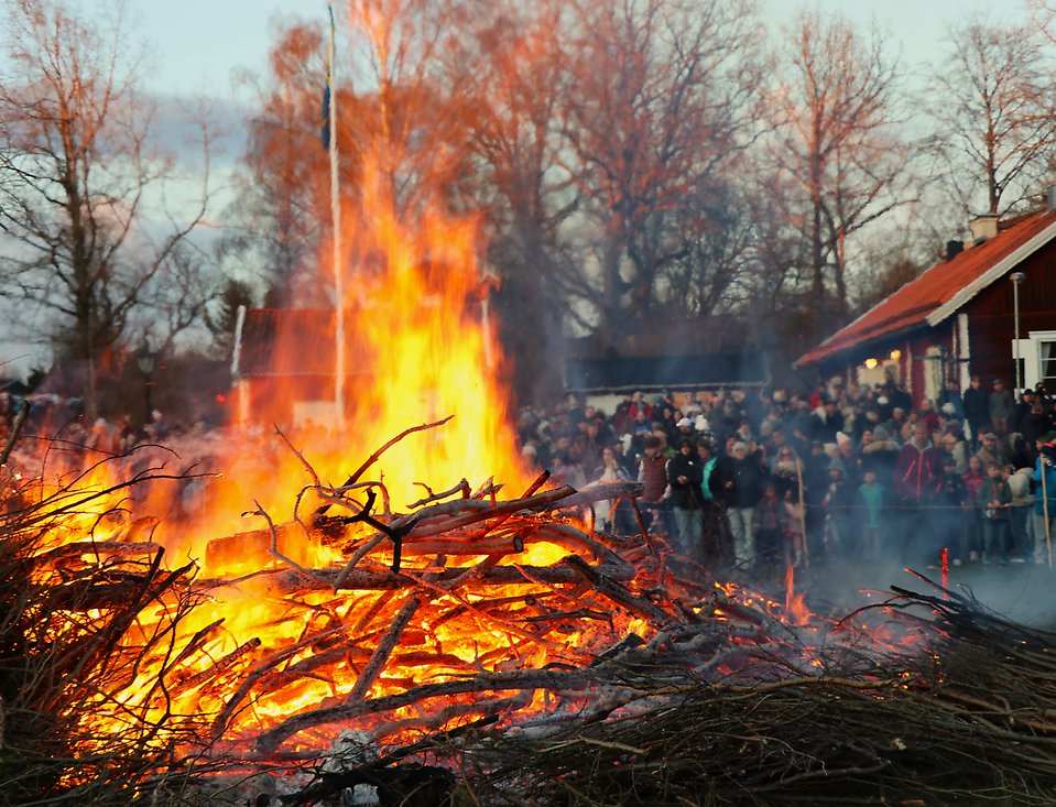 En stor brasa och folk som samlats kring den.